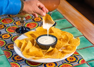 a plate of nachos and a drink on a table