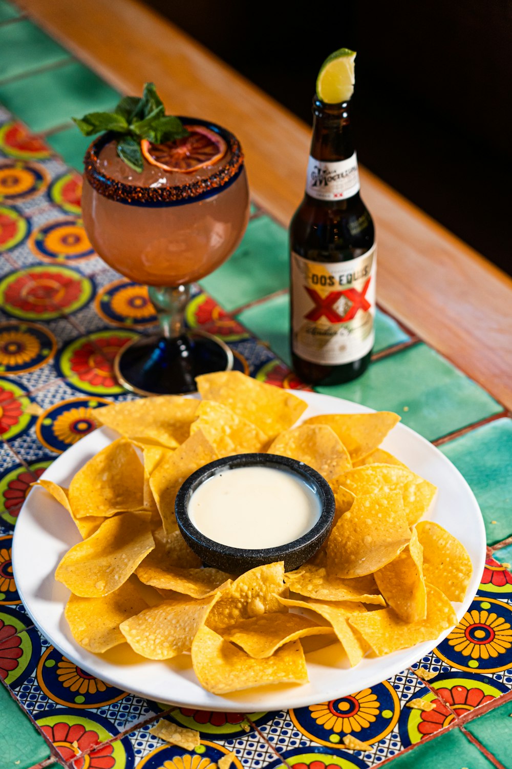 a plate of tortilla chips and a bottle of beer