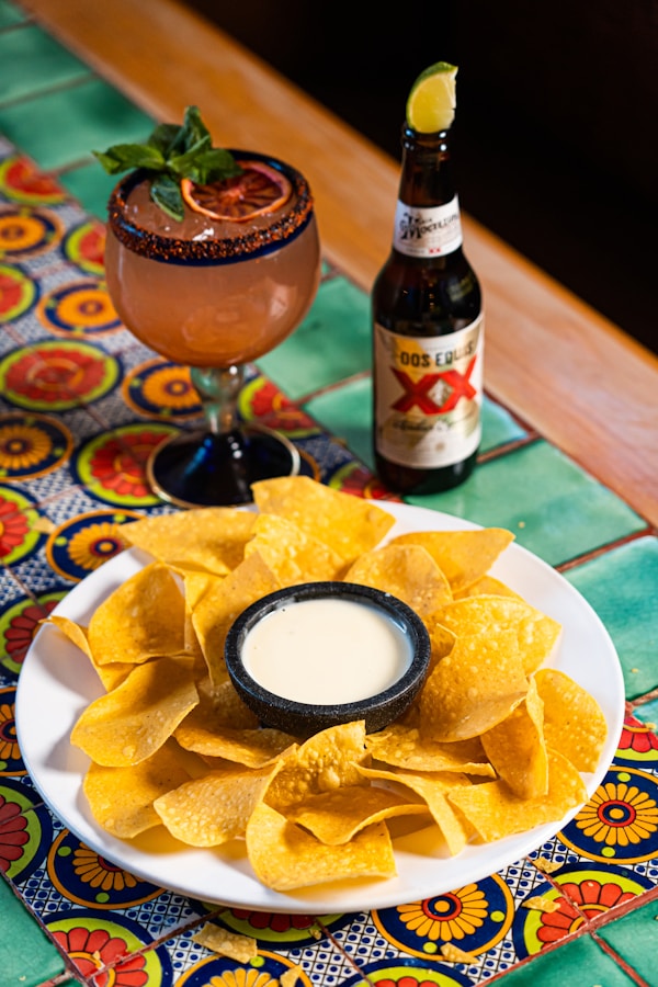 A plate of tortilla chips and a bottle of beer