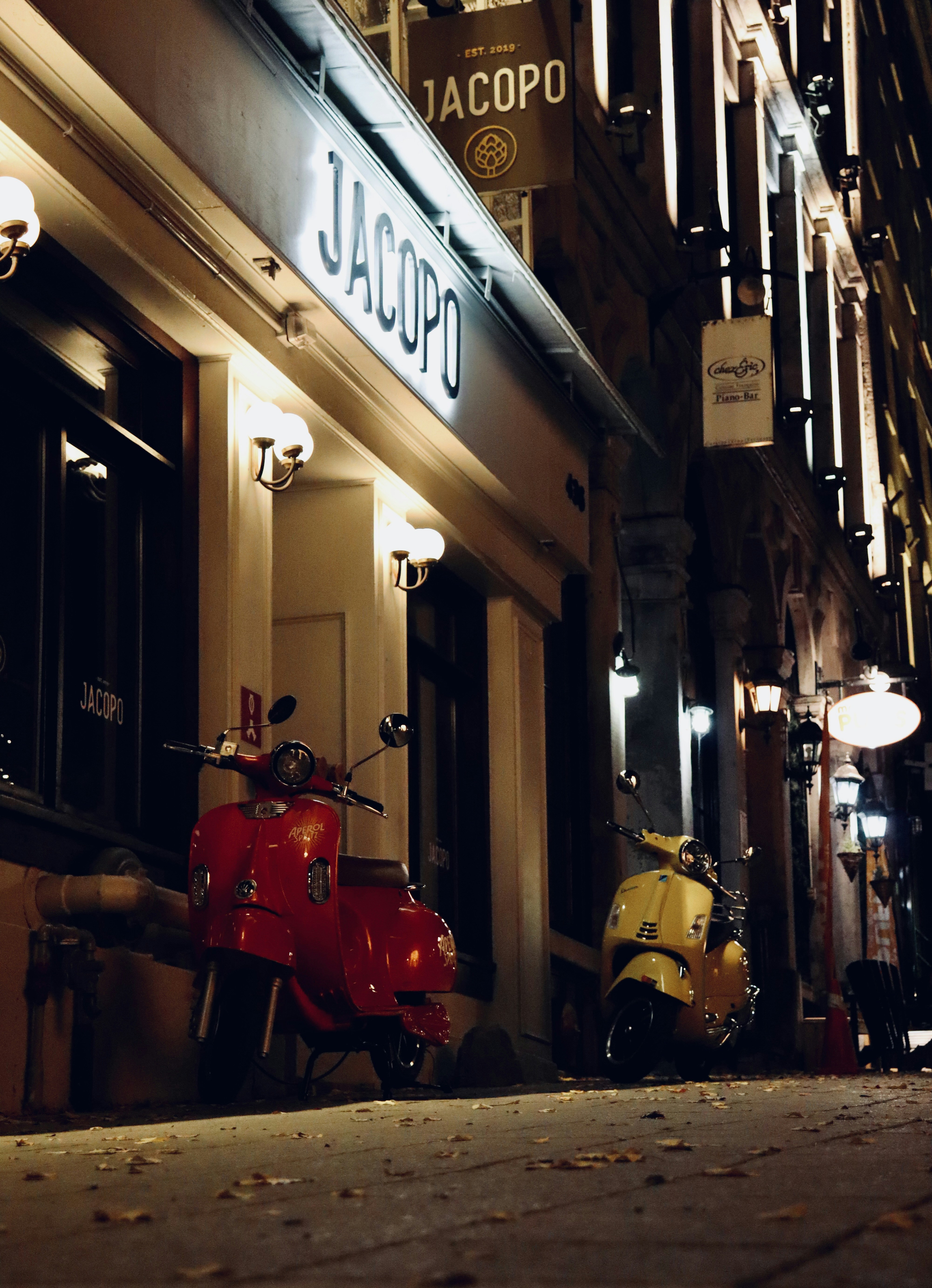 a red scooter is parked outside of a restaurant