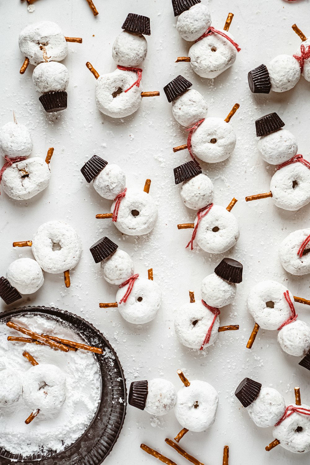 uma mesa coberta com marshmallows e bonecos de neve cobertos de chocolate
