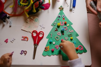 a child is making a christmas tree out of felt