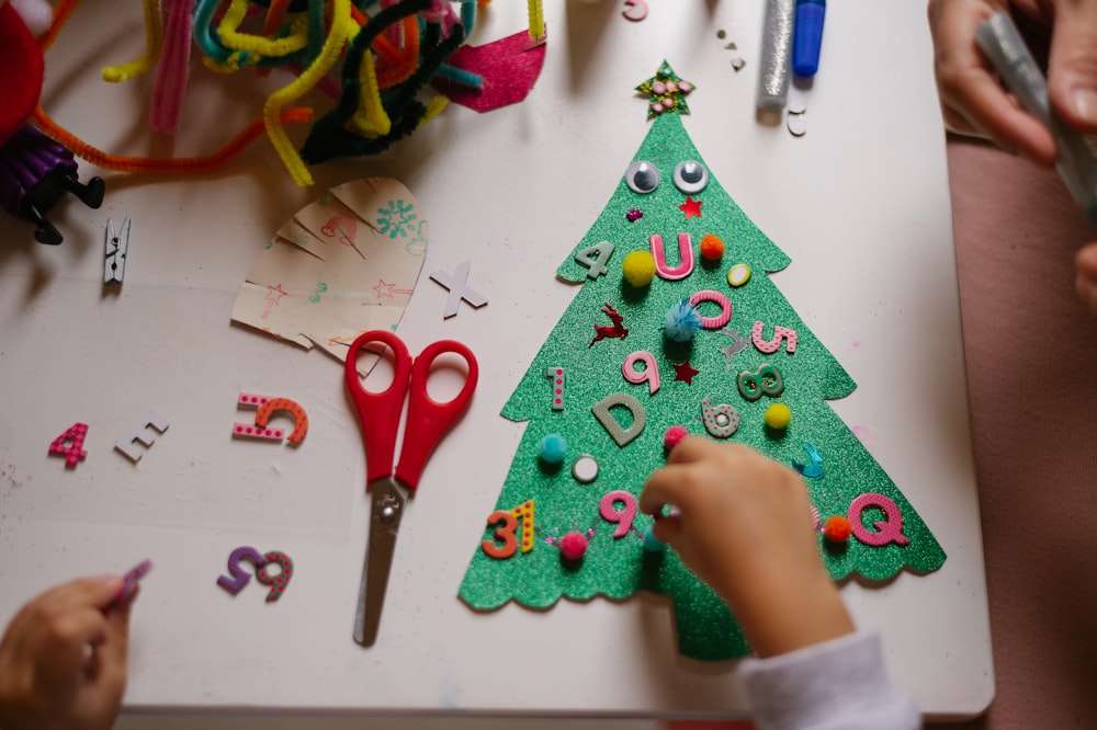 a child is making a christmas tree out of felt