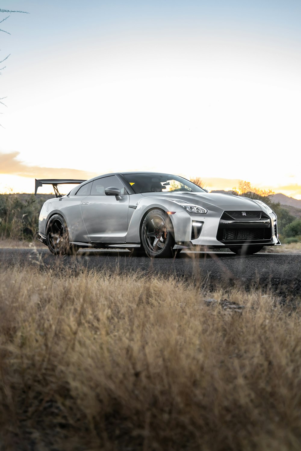 a silver sports car parked on the side of the road