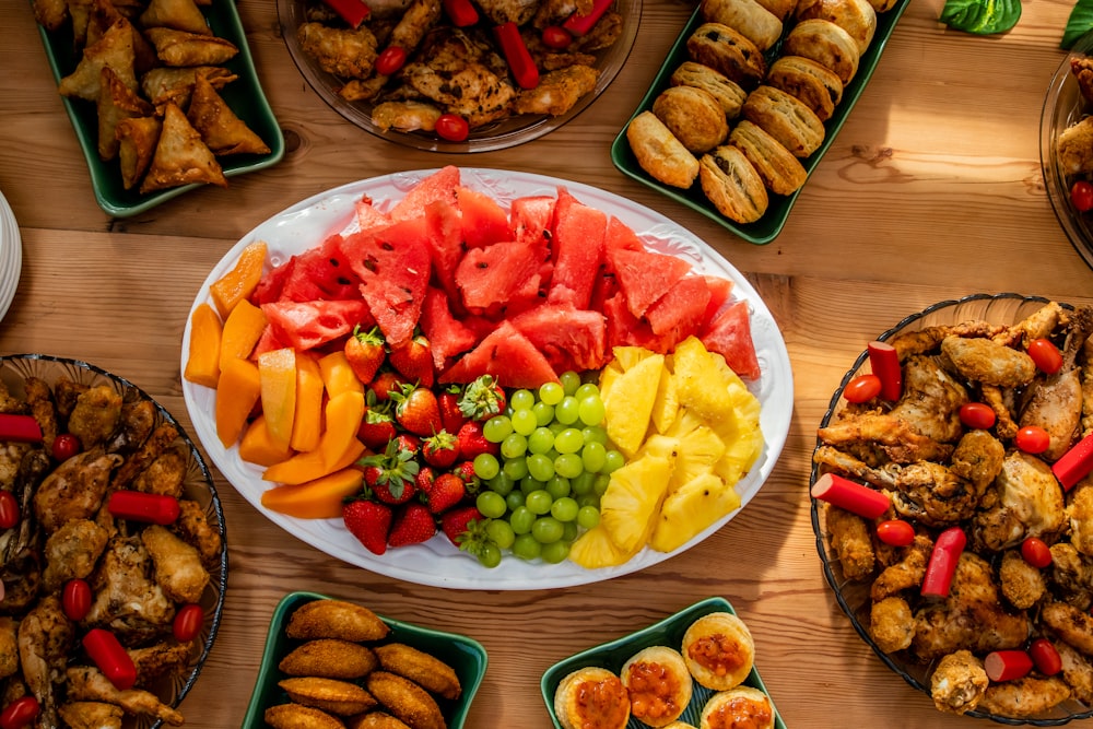 a table topped with plates of food covered in fruit