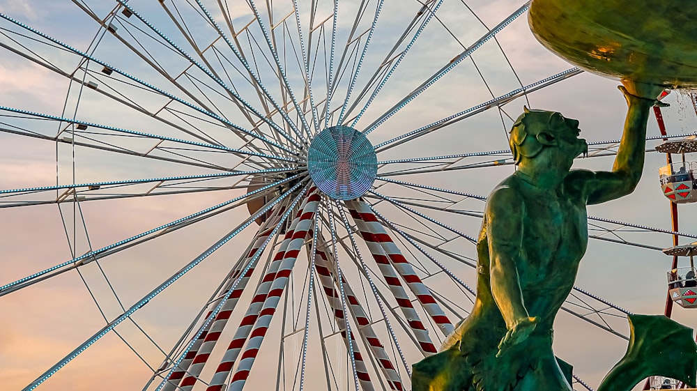 a statue of a man holding onto a ferris wheel