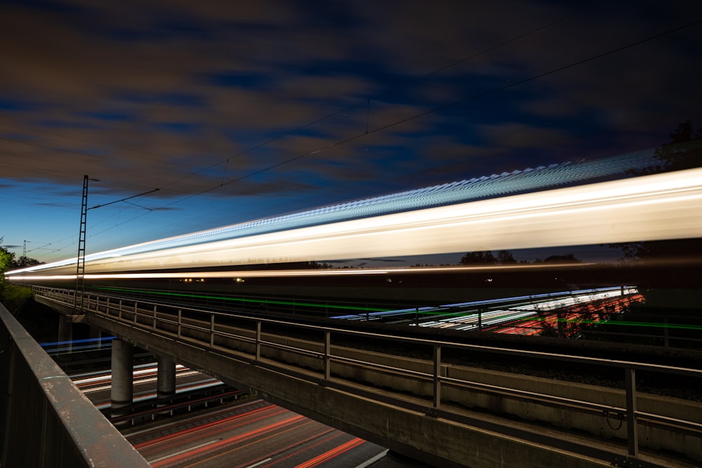 a long exposure photo of a train on a bridge