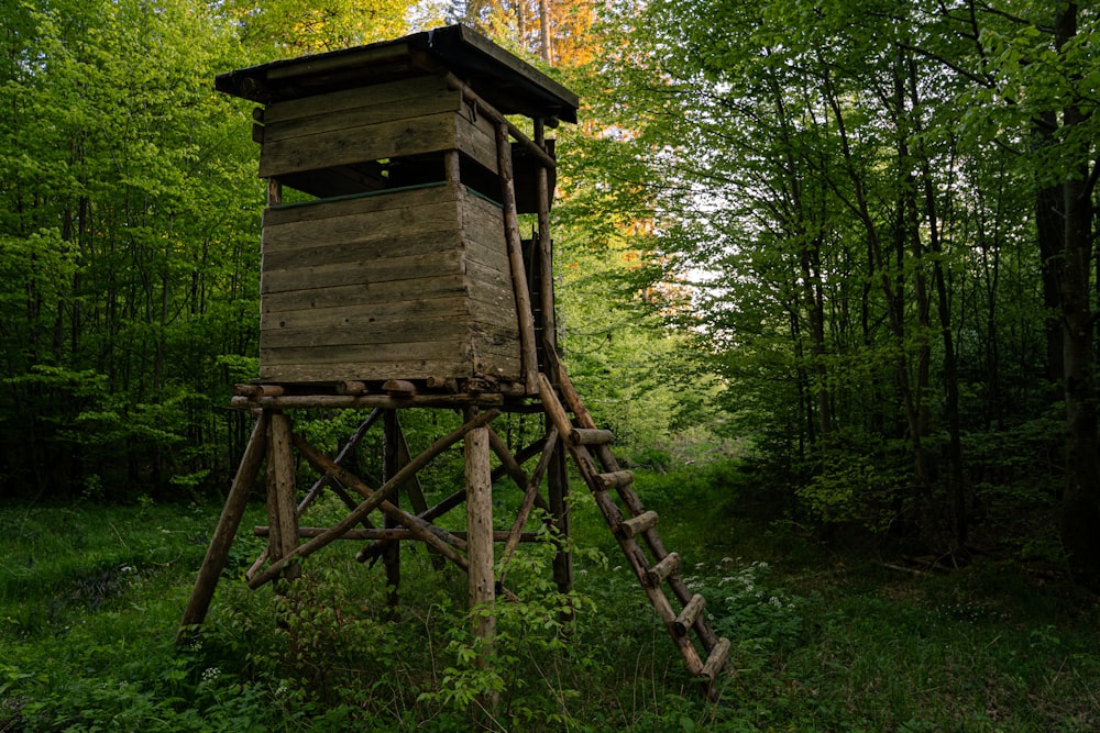 a wooden tower in the middle of a forest