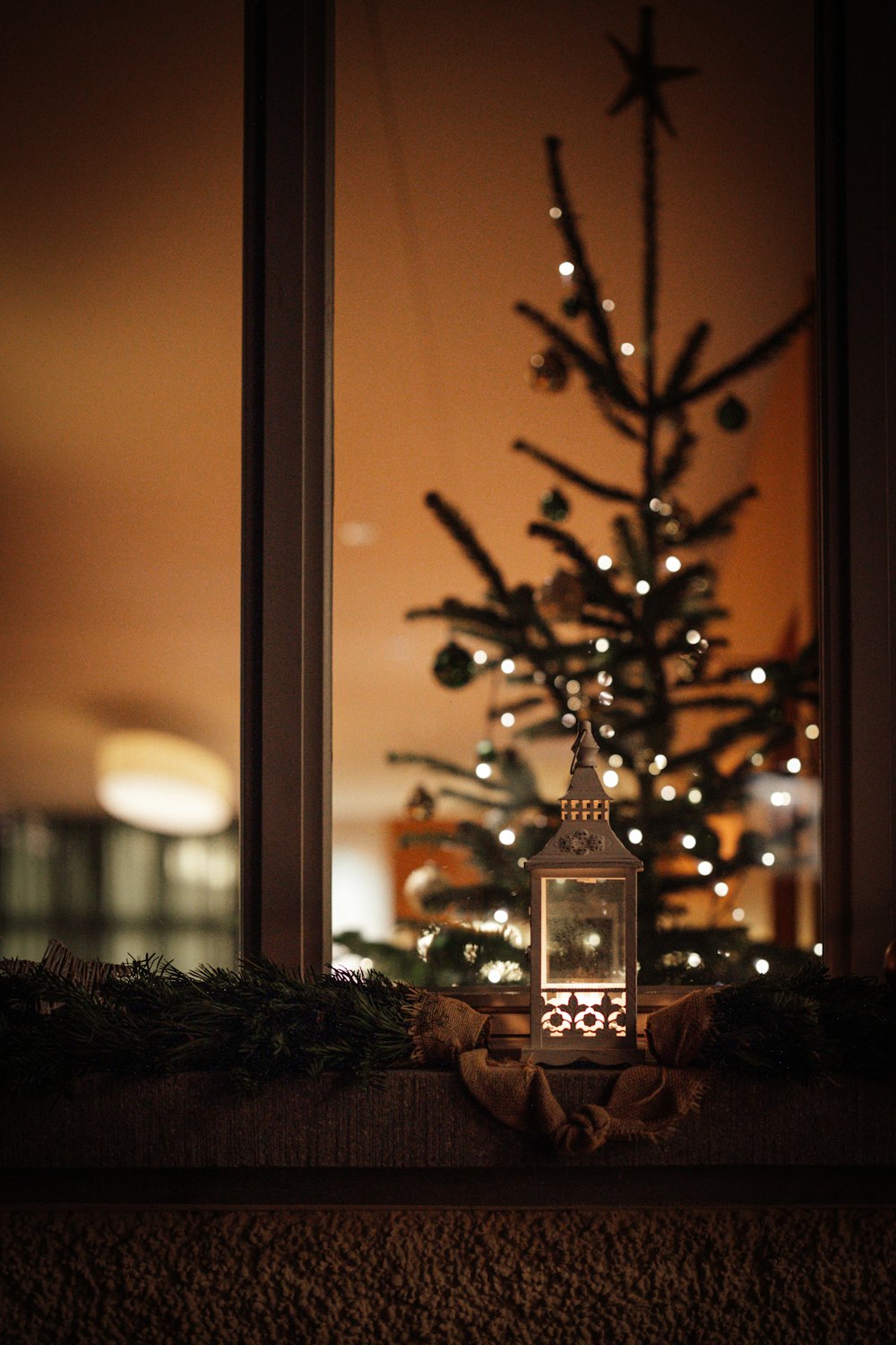 Un pequeño árbol de Navidad frente a una ventana
