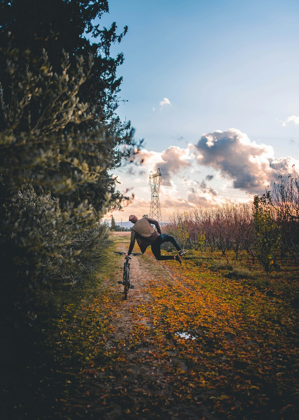 a man riding a bike down a dirt road