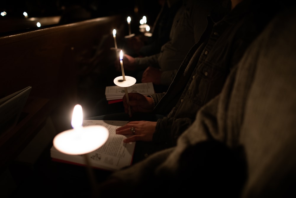 people sitting in a church with lit candles