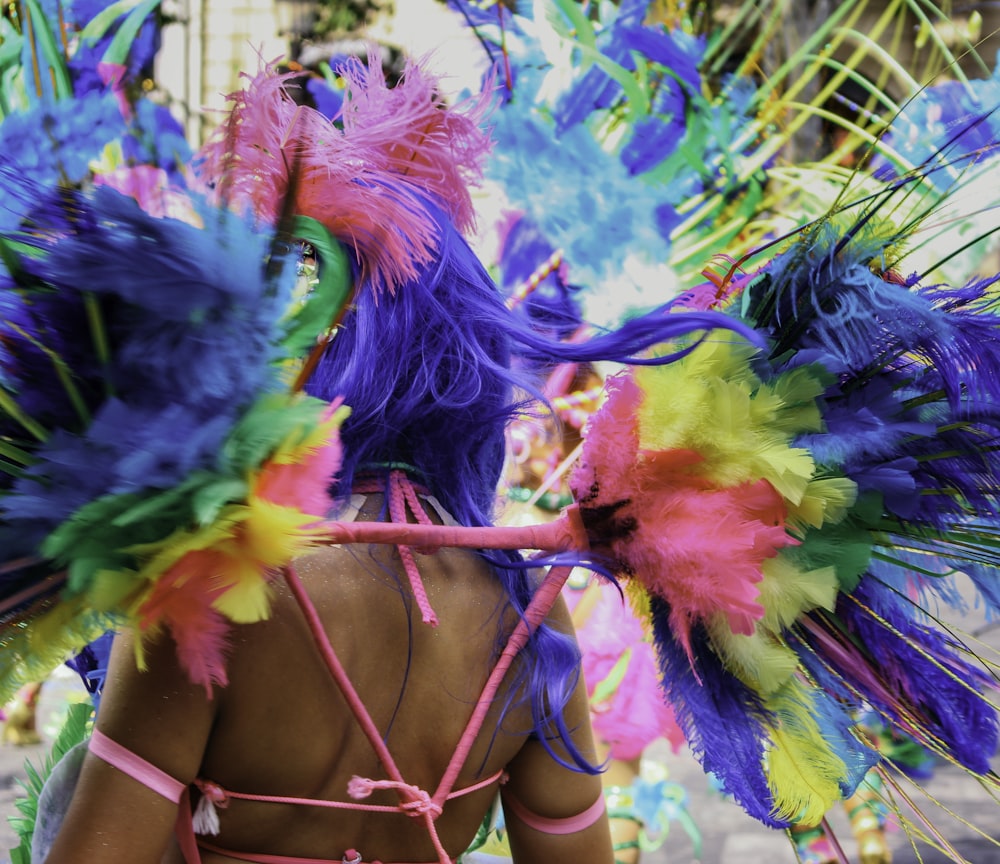 uma mulher vestindo um cocar colorido em um desfile