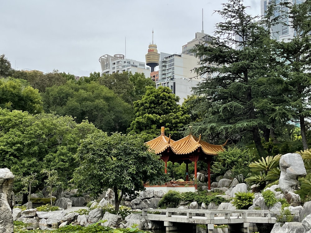 a gazebo surrounded by rocks and trees in a park