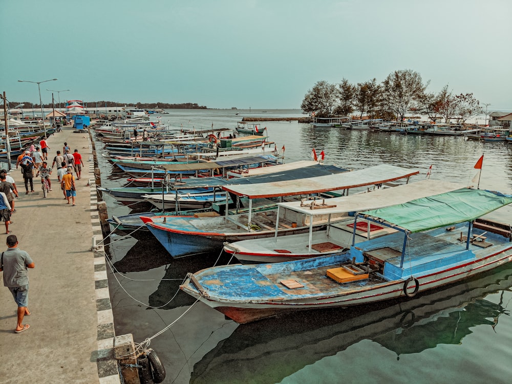 a group of boats docked next to a pier