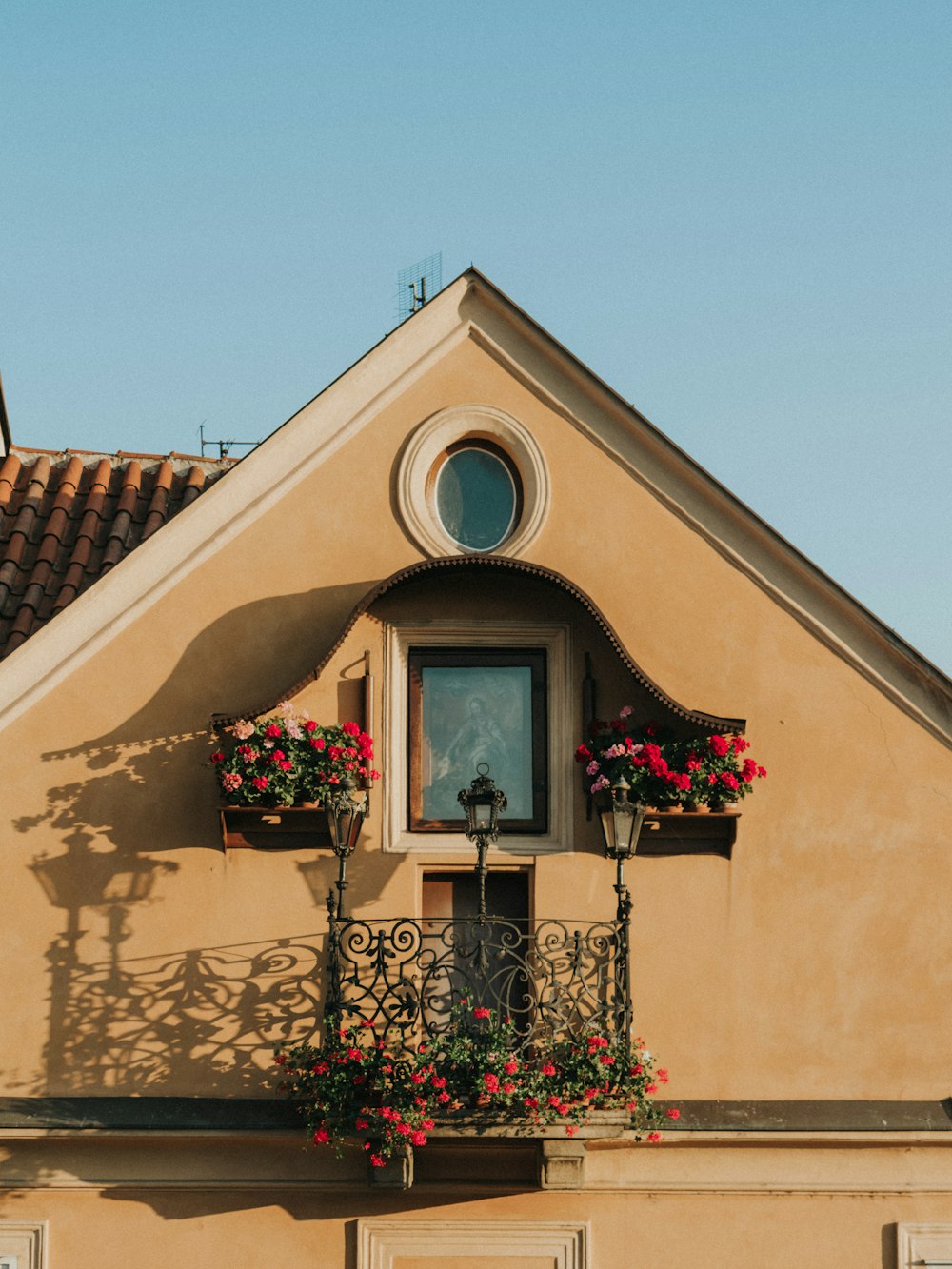 a building with a window and a balcony with flowers on it