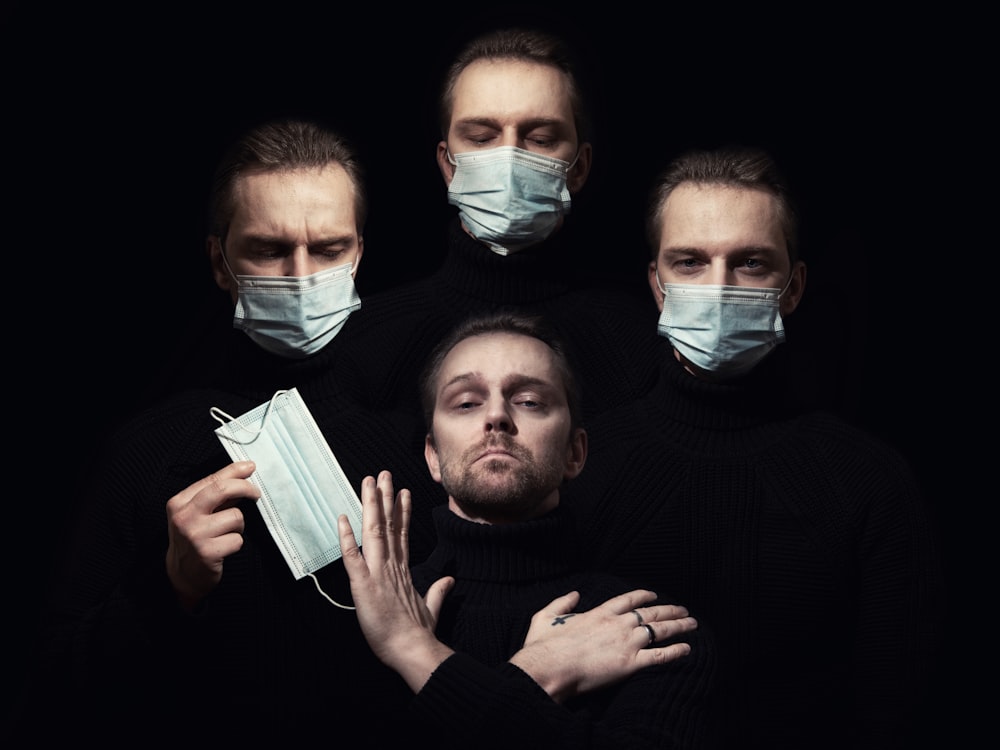 a group of men wearing face masks and covering their faces