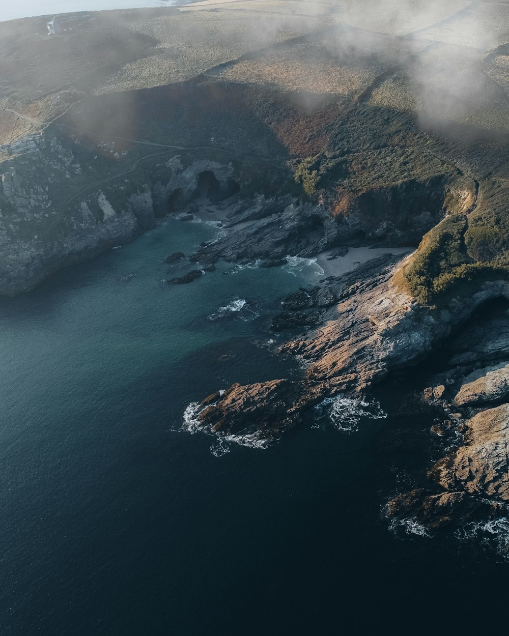 an aerial view of a body of water surrounded by mountains