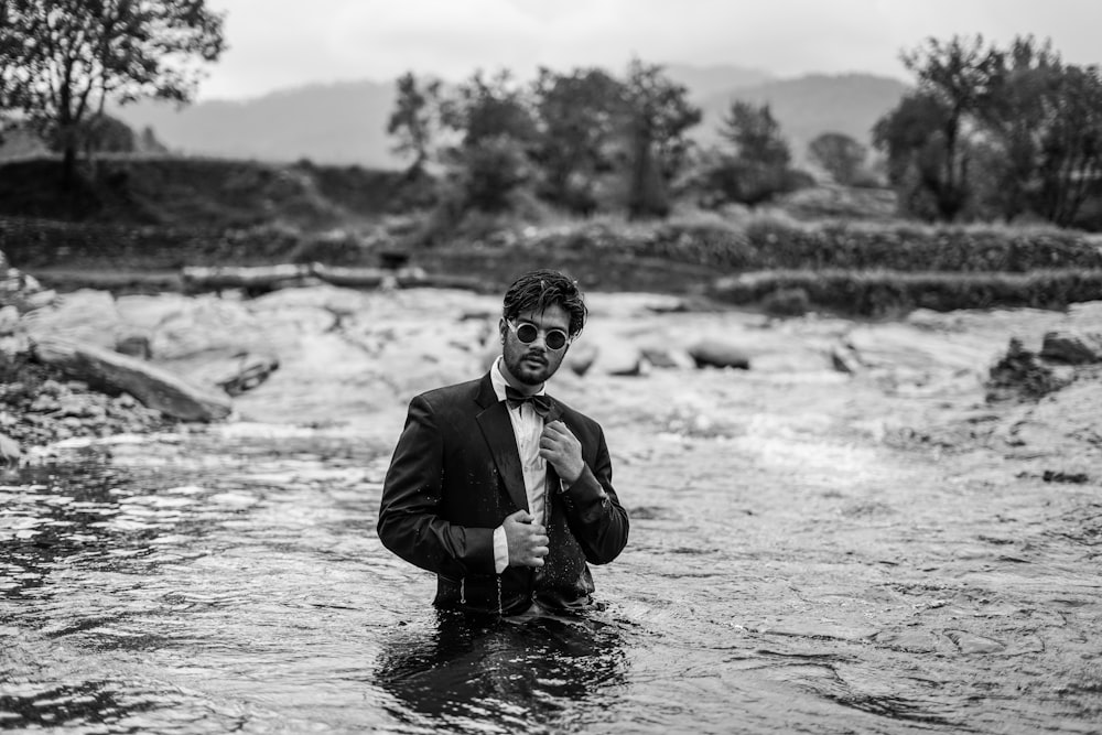 a man in a suit standing in a river