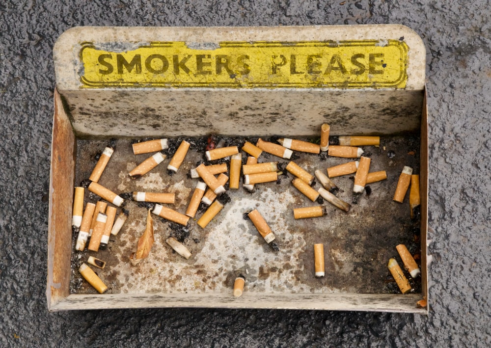 a box filled with lots of cigarettes sitting on top of a cement floor