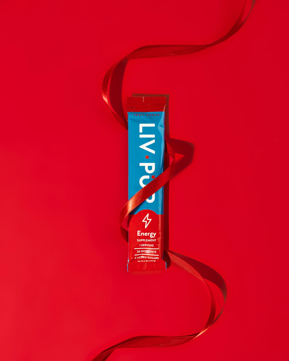un tubo de pasta de dientes sobre un fondo rojo