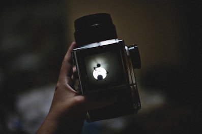a person holding a camera with an apple logo on it