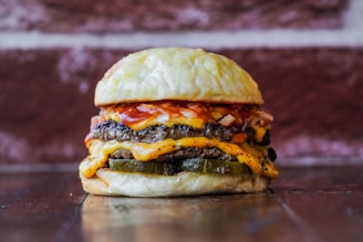 a cheeseburger on a bun with a pickle on the side