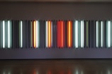 A row of compact smart light panels casting vibrant hues against a clean white backdrop.
