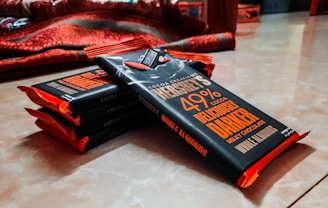 Stacks of chocolate bars wrapped in elegant packaging with the js sweets logo visible.