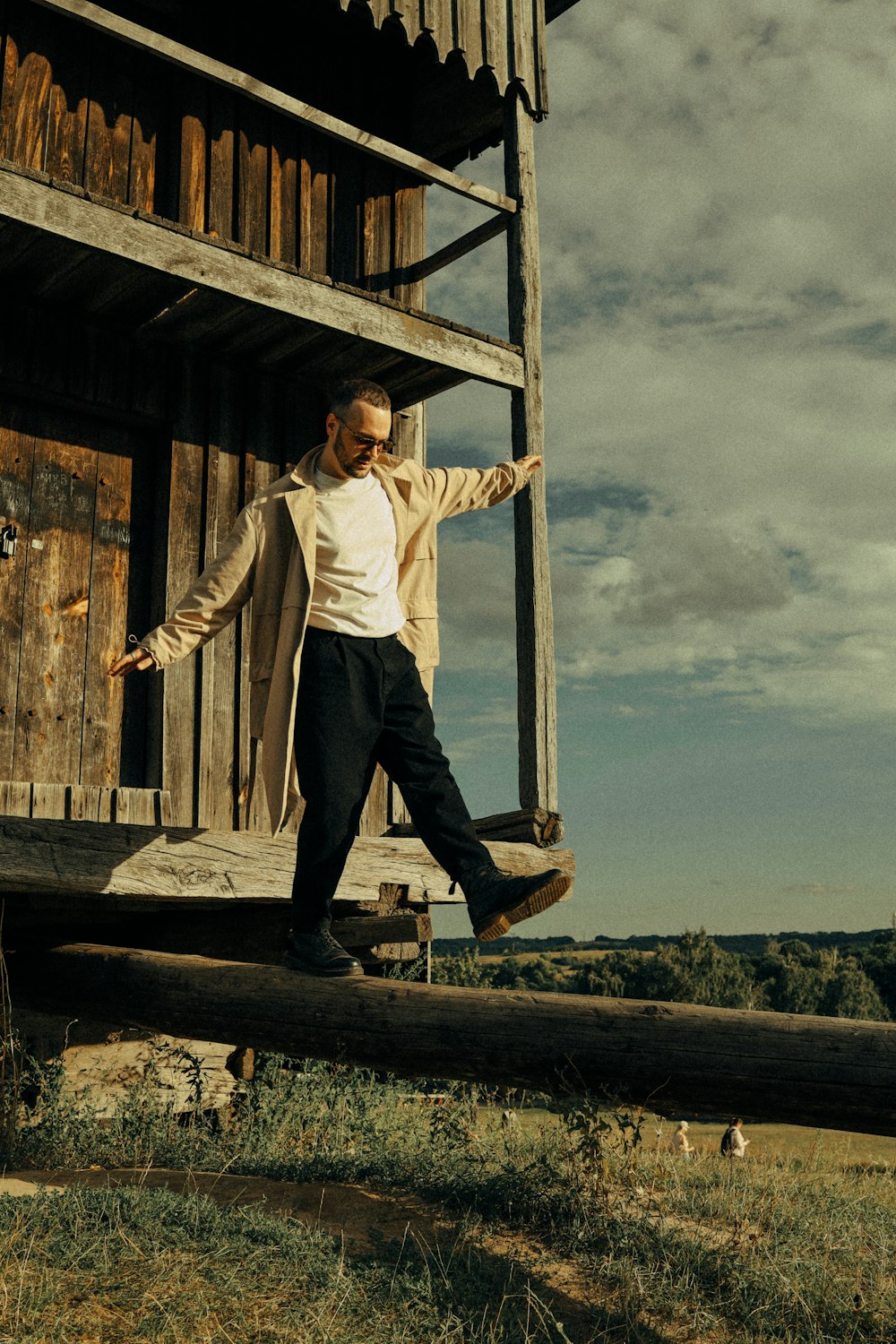 a man standing on a log in front of a building