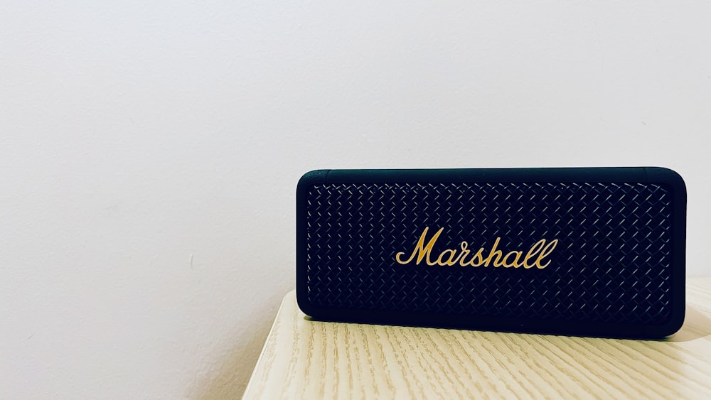 a black speaker sitting on top of a wooden table