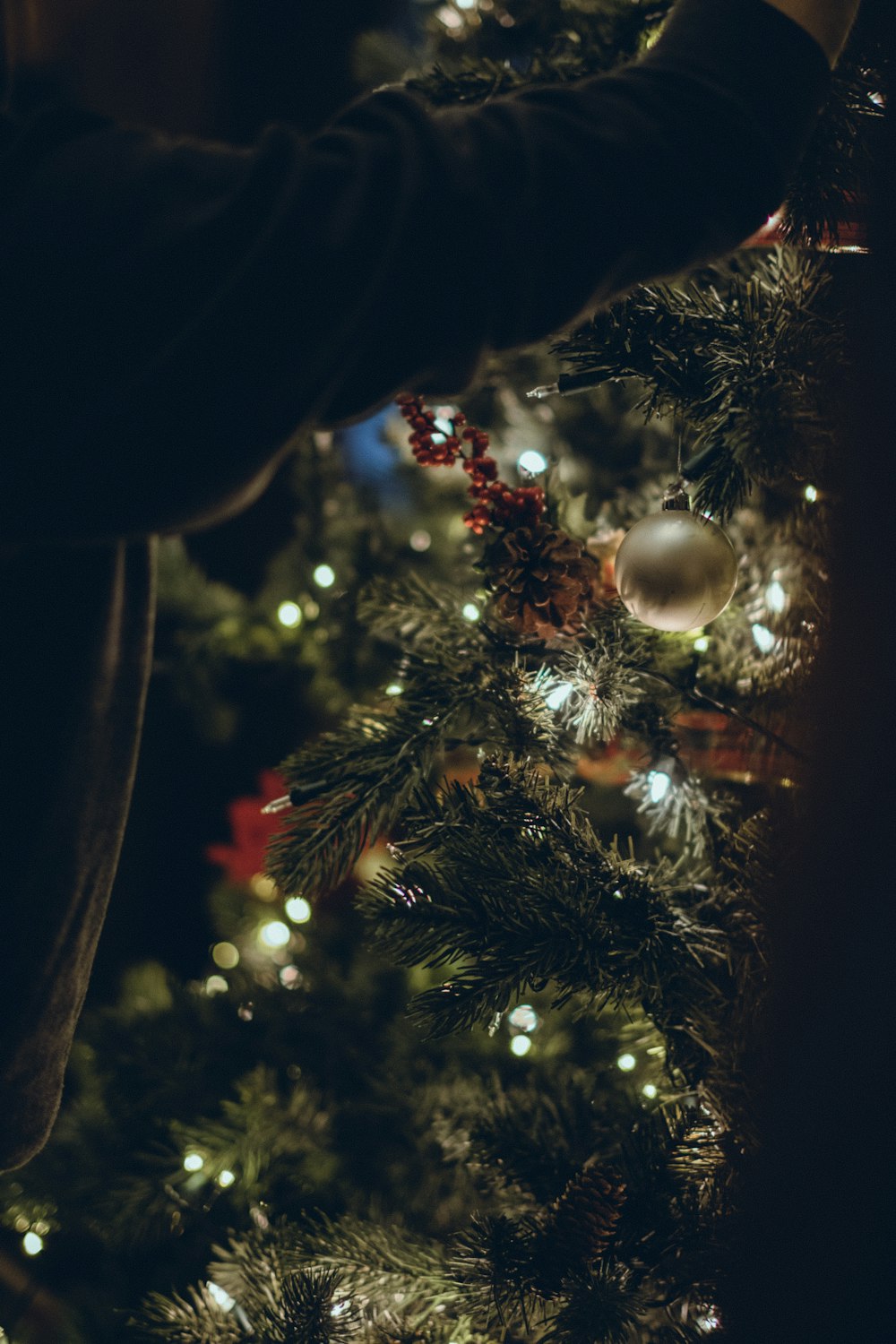 a close up of a person decorating a christmas tree