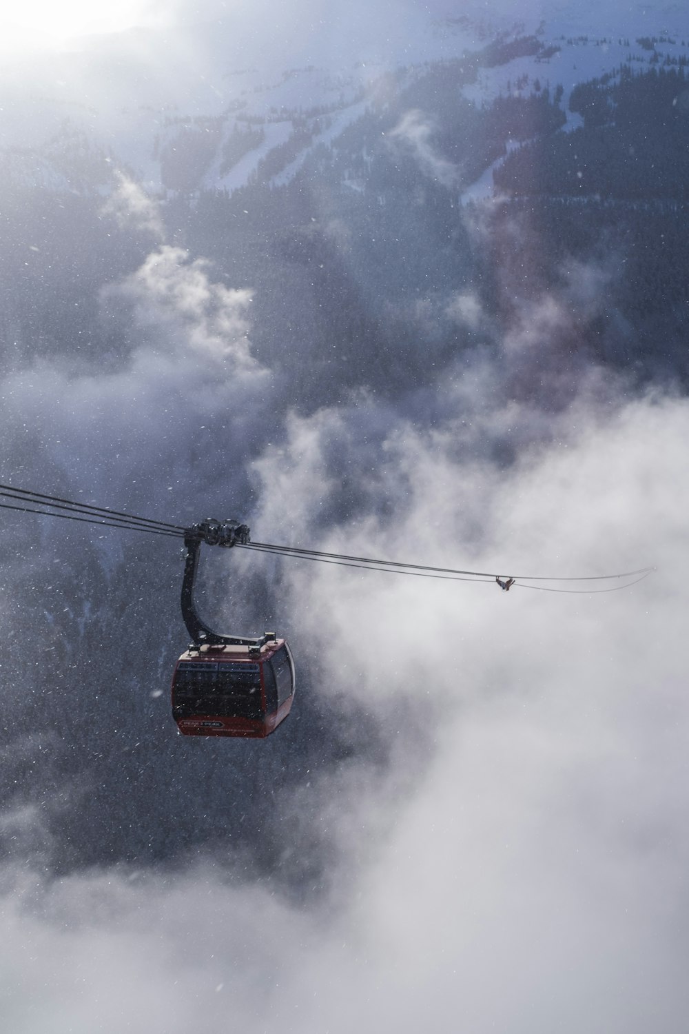 a gondola suspended above the clouds in the mountains