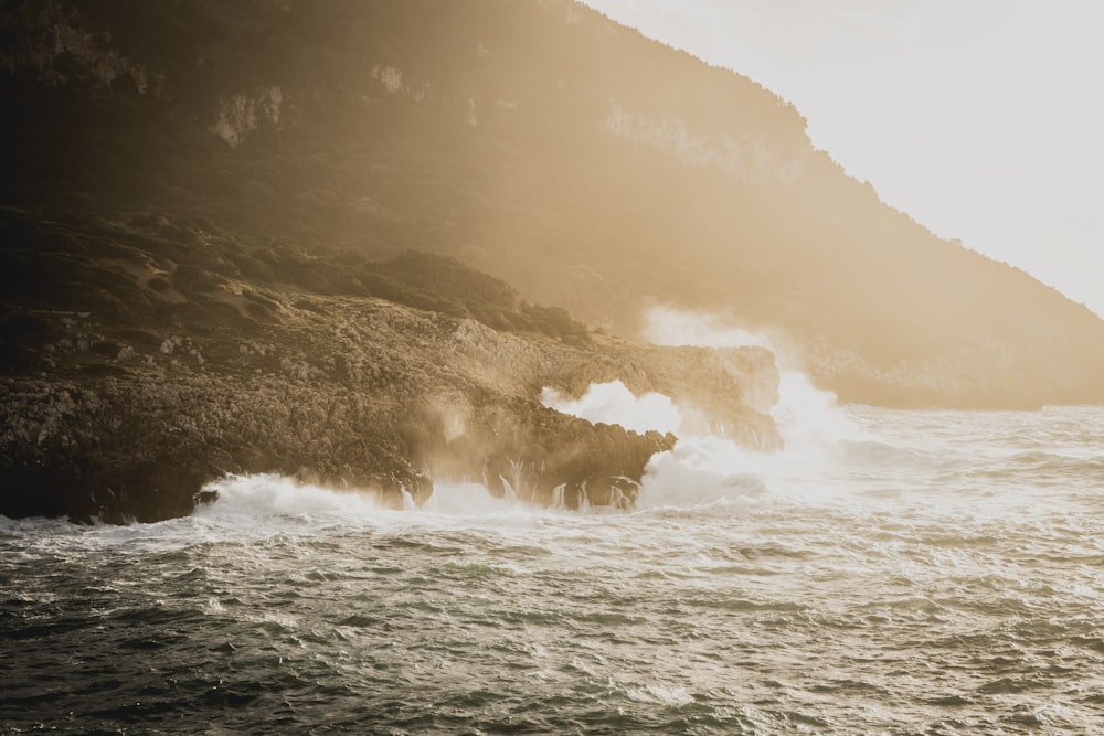 a large body of water next to a rocky cliff