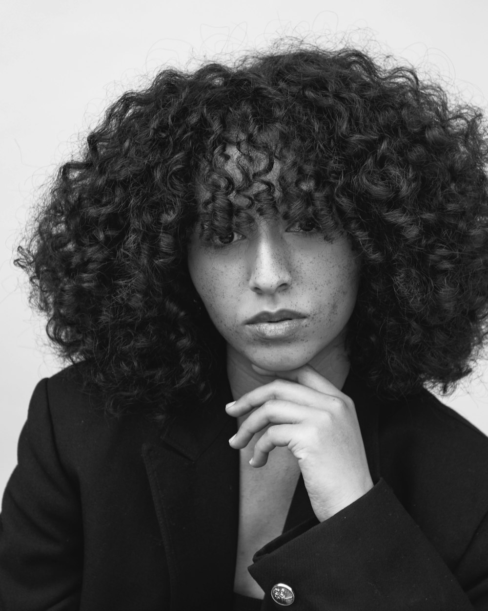 a black and white photo of a woman with curly hair