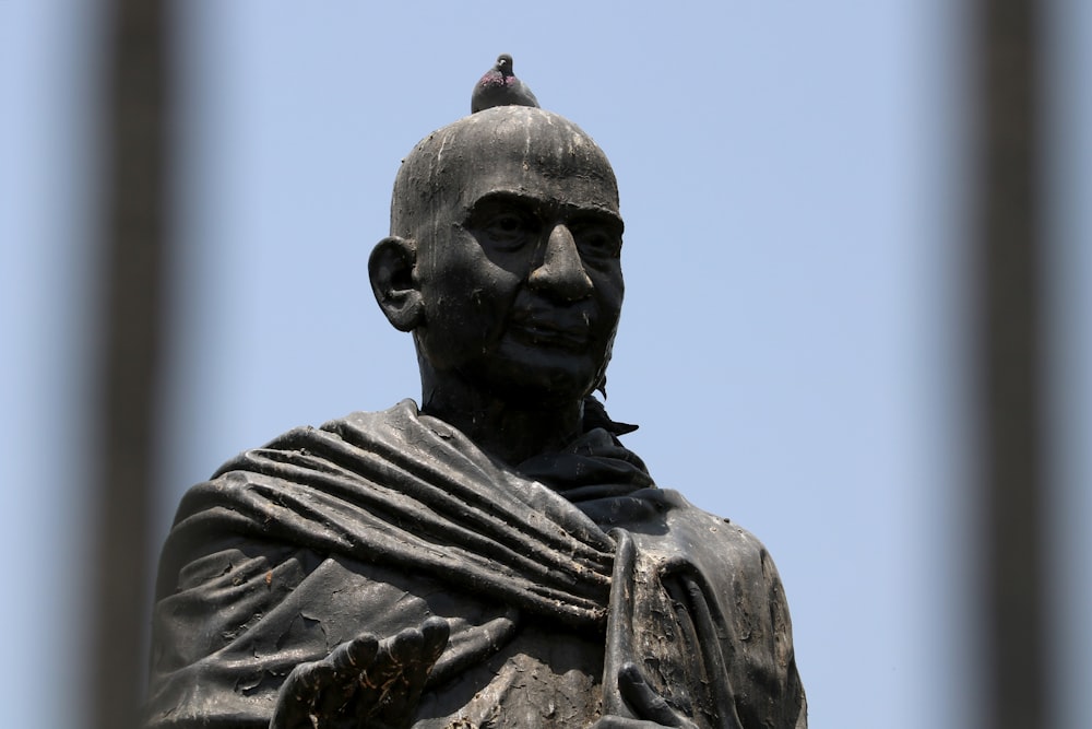 a statue of a man with a bird on his head