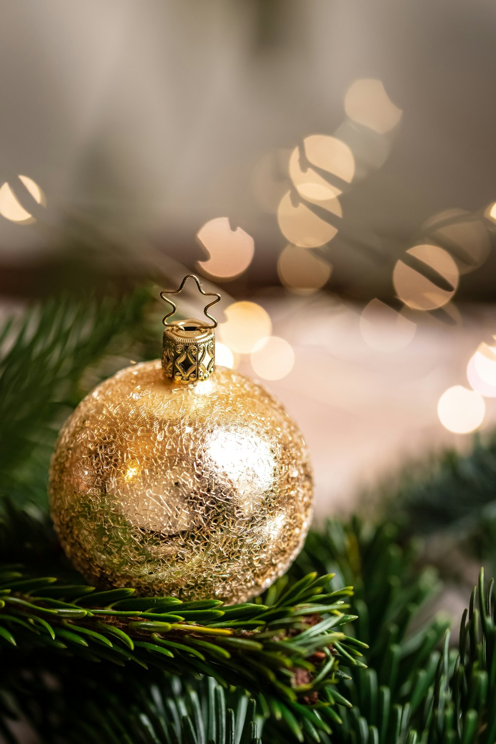 a gold ornament hanging from a christmas tree