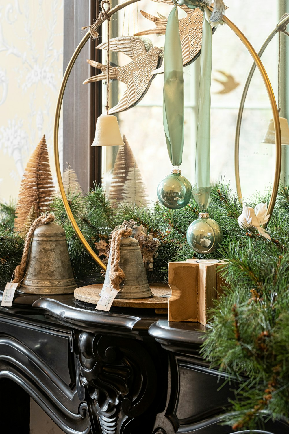 a mantle decorated with christmas decorations and bells