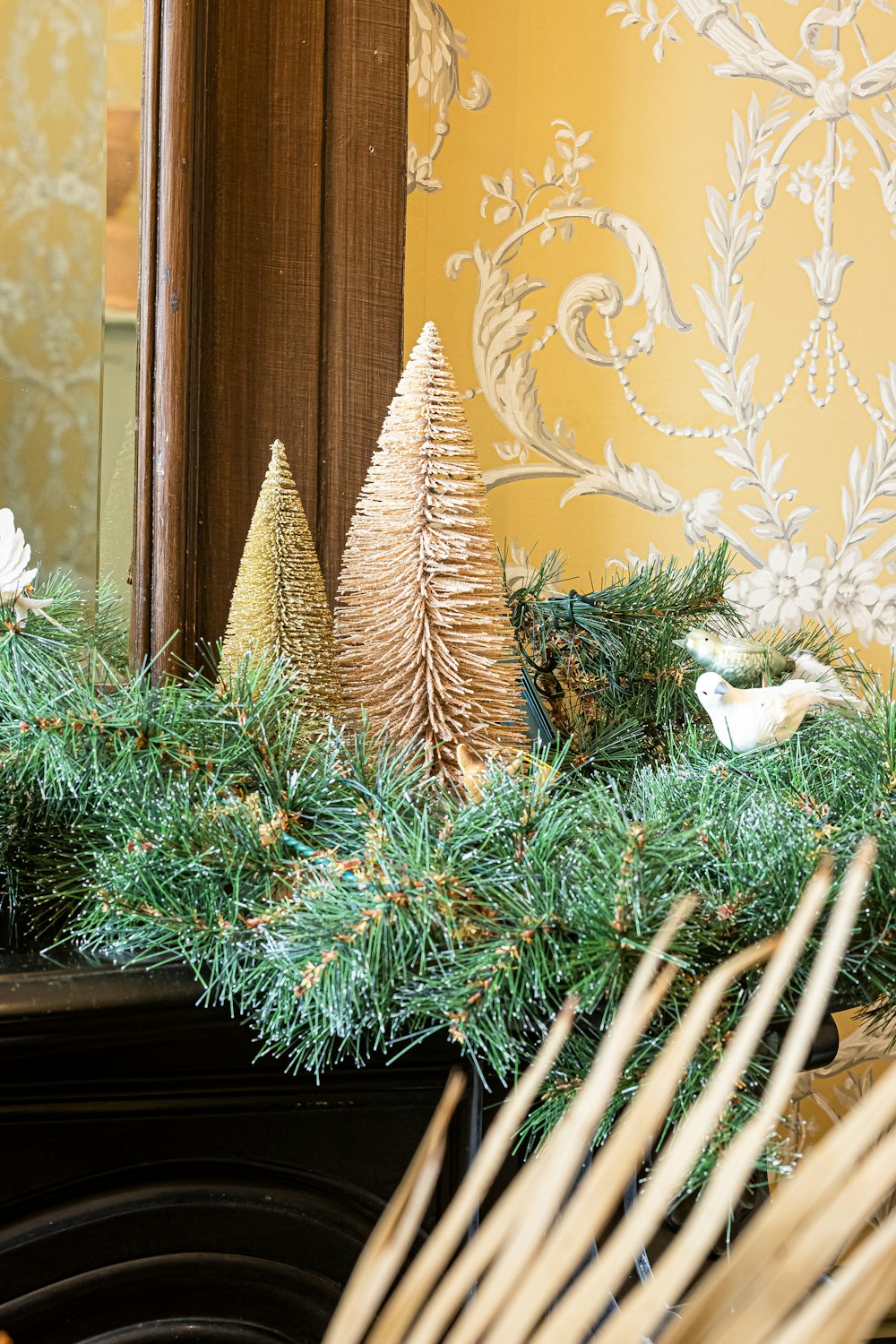 a christmas mantle decorated with pine cones and evergreen needles