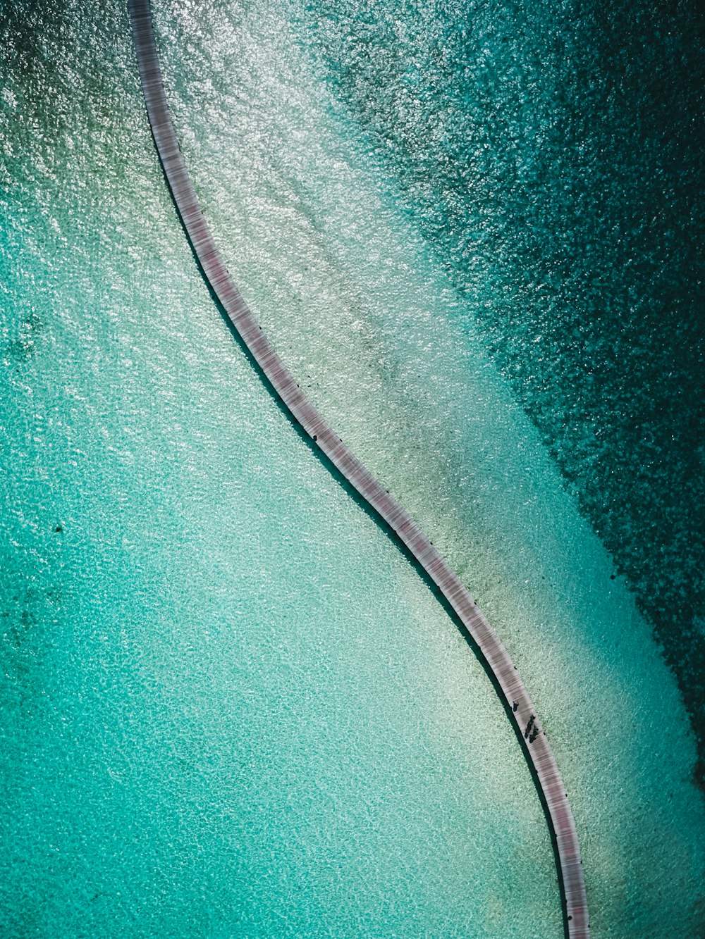 an aerial view of a pier in the water