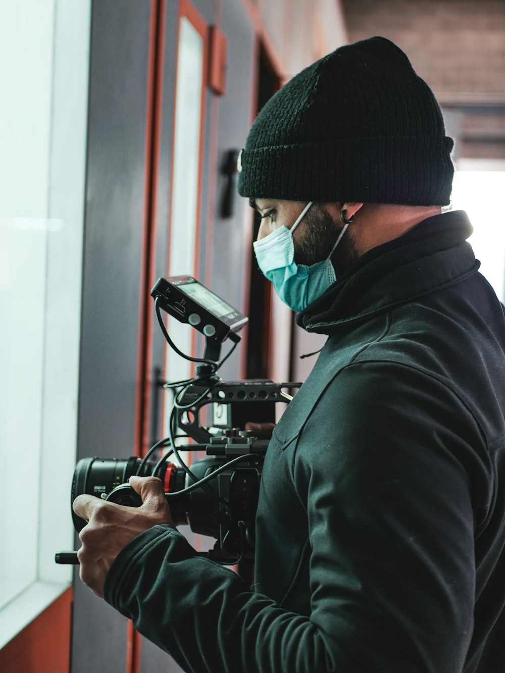 a man wearing a face mask and holding a camera