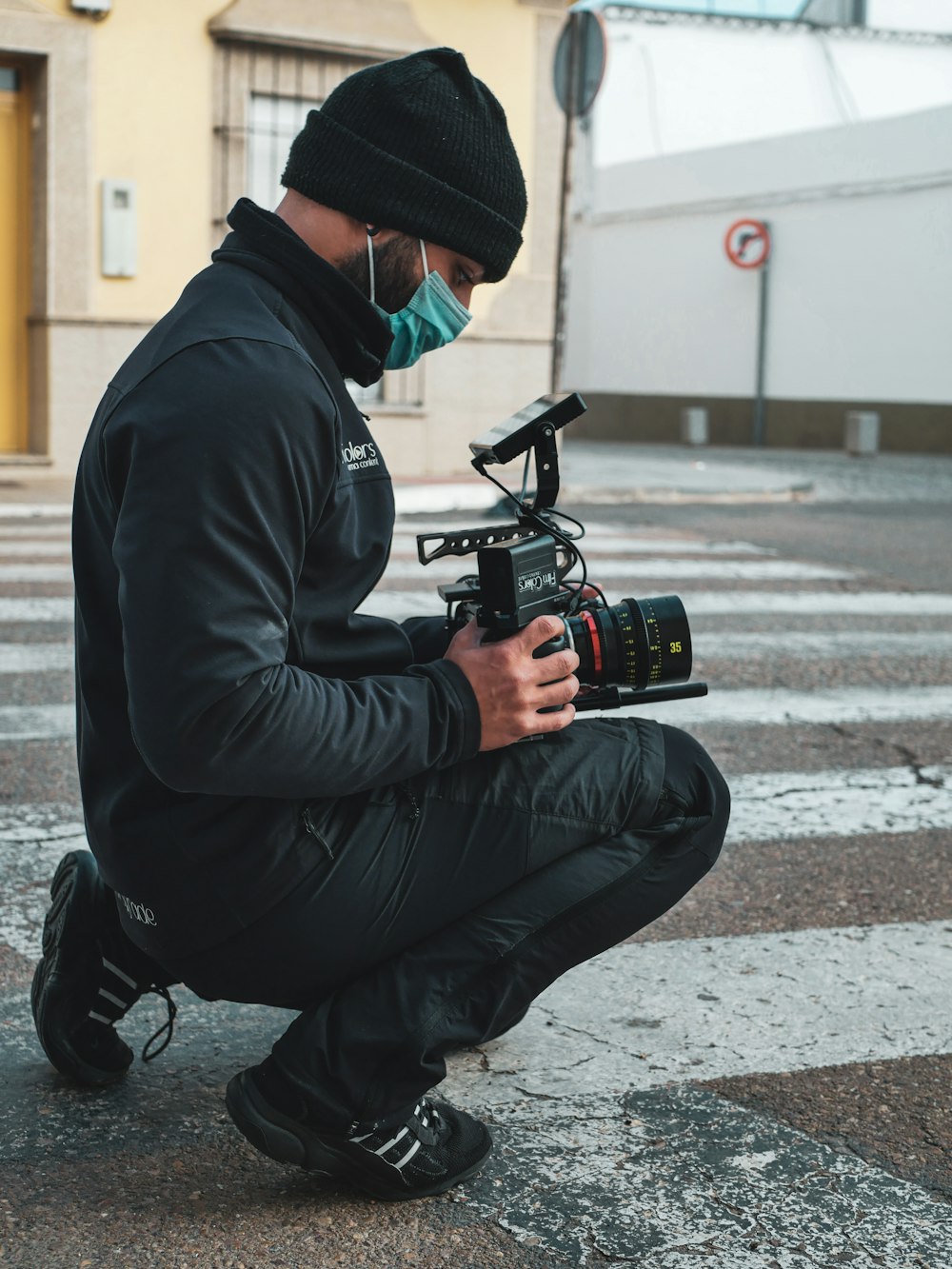 a man squatting down while holding a camera