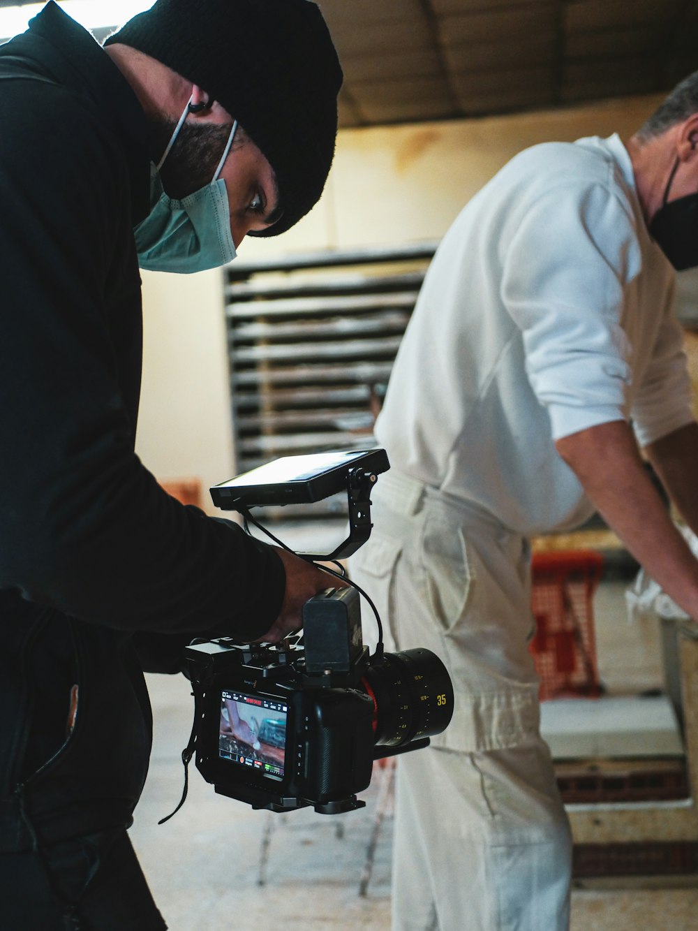 two men wearing masks and holding a camera