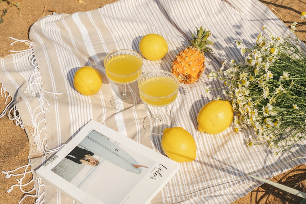 a table topped with glasses of juice and lemons