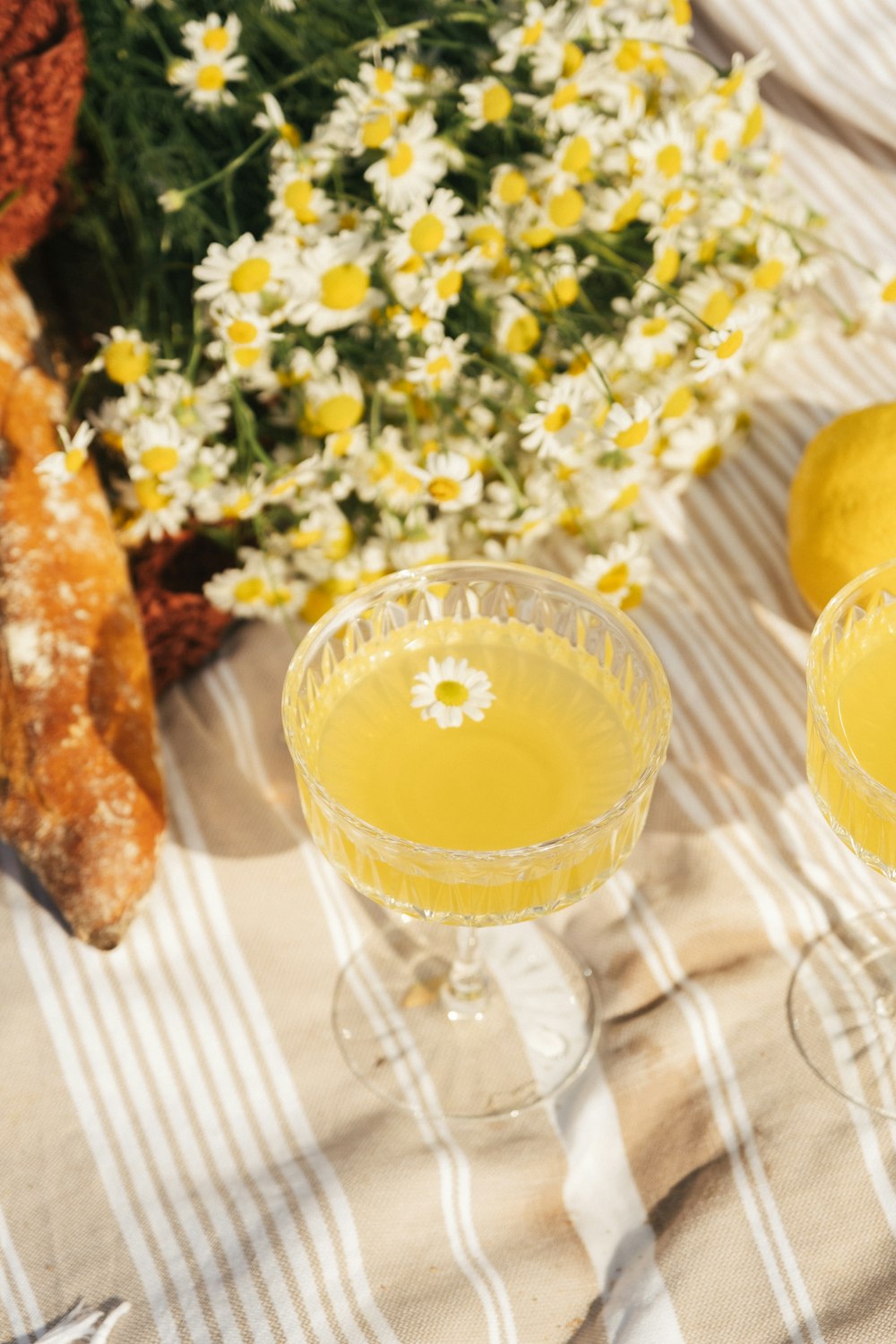 two glasses filled with yellow liquid sitting on a table