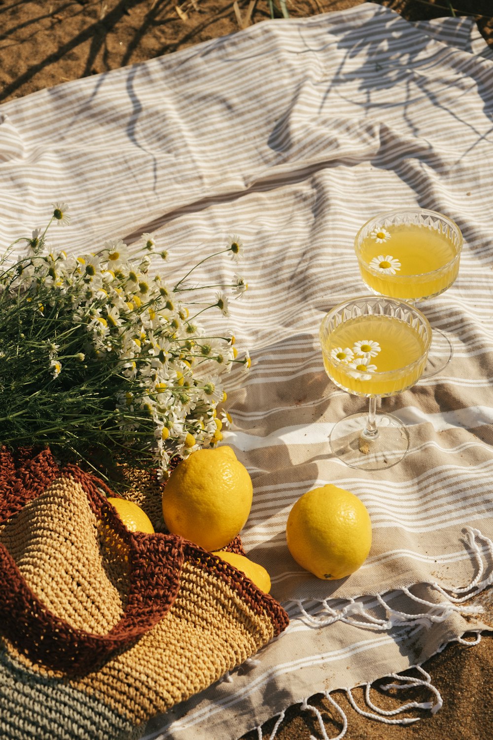 Due bicchieri di limonata, un cappello di paglia e un sacchetto di paglia su un