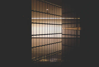 a dark room with a light coming through the blinds