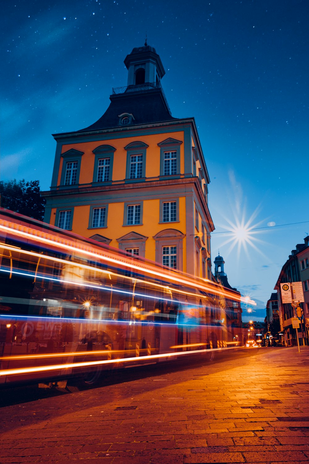 a double decker bus driving down a street at night