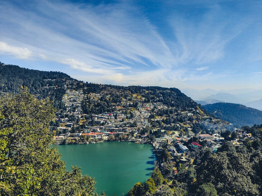 a lake surrounded by trees and mountains under a blue sky