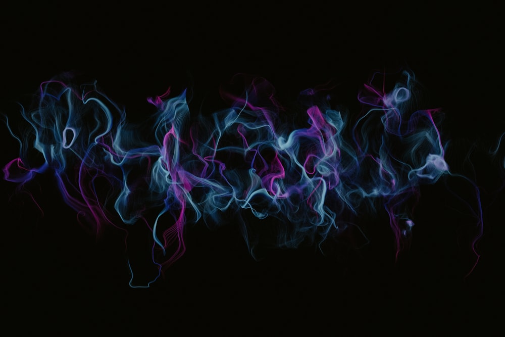 a black background with blue and pink smoke