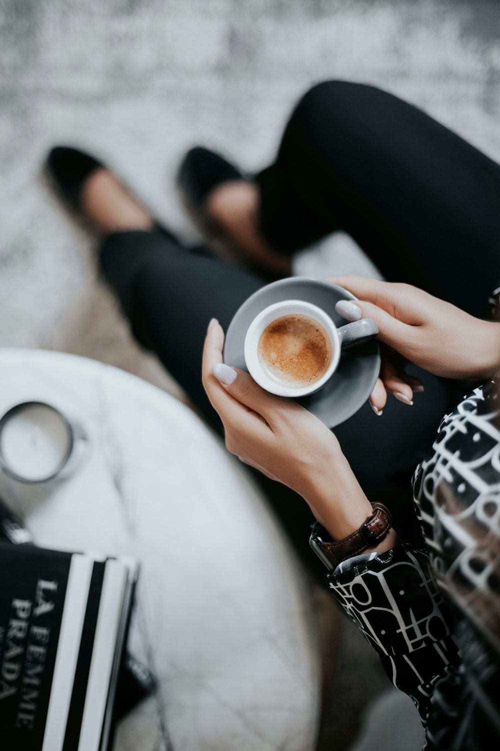 a woman is holding a cup of coffee